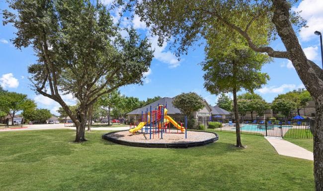 a playground with trees and grass